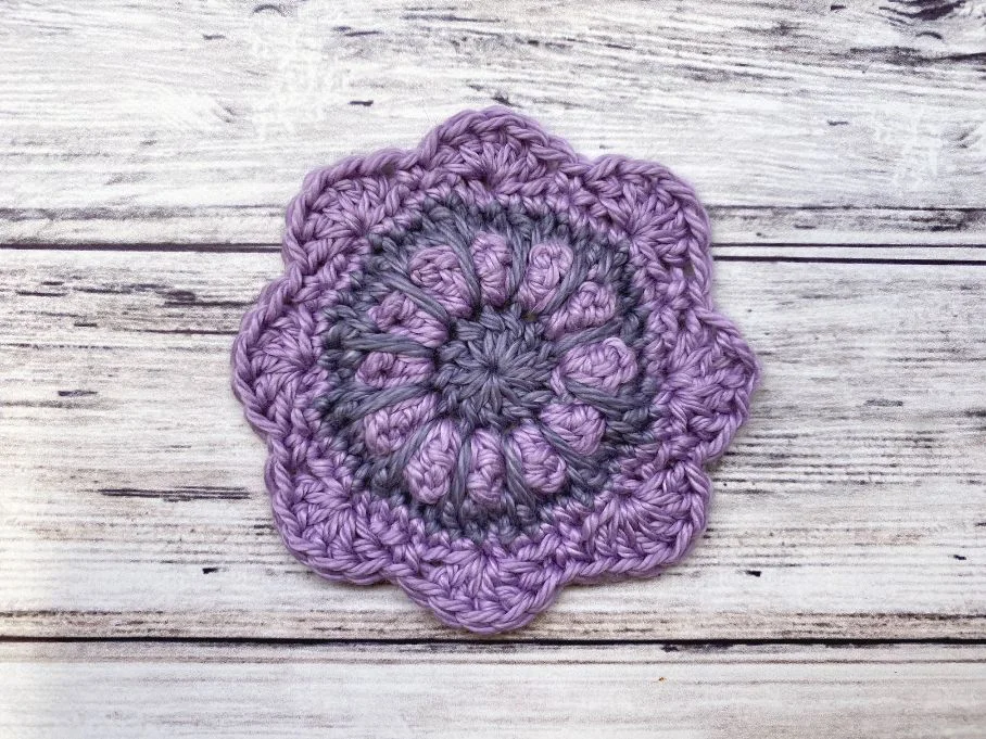 crochet face scrubby on wooden background